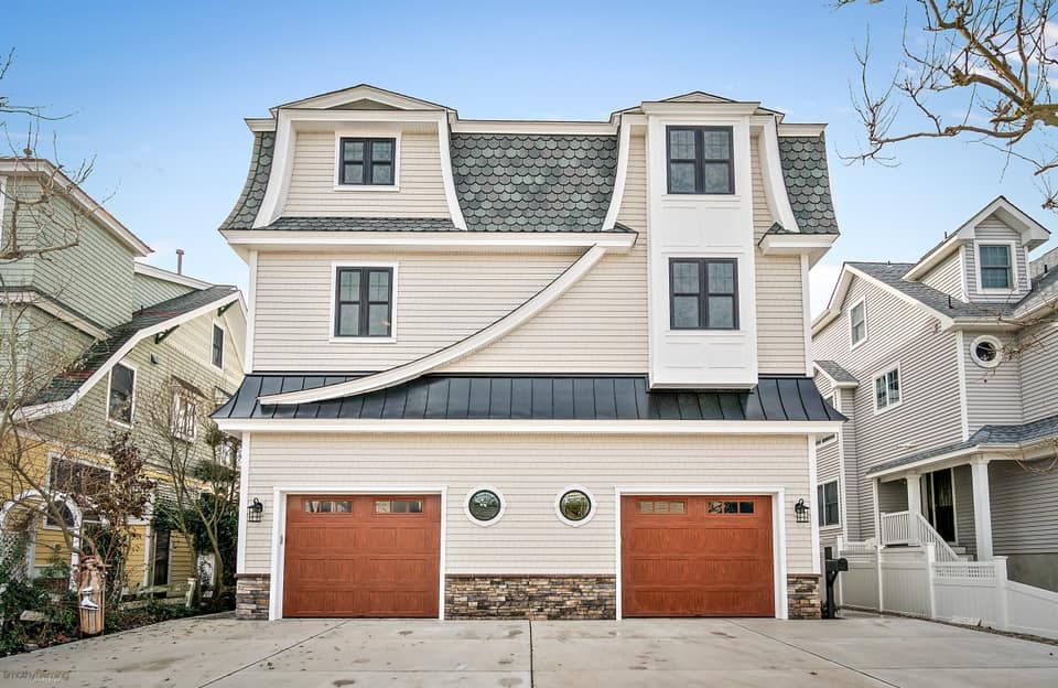 new beige house with brown garage doors, dark windows, and gray roof built in sea isle city, new jersey by j.k. construction llc