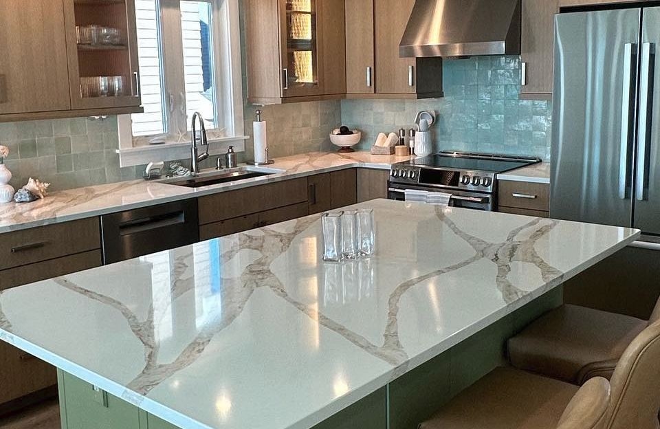 Kitchen with large white island countertop, wooden cabinets, and turquoise backsplash remodeled by j.k. construction llc in ocean city, new jersey
