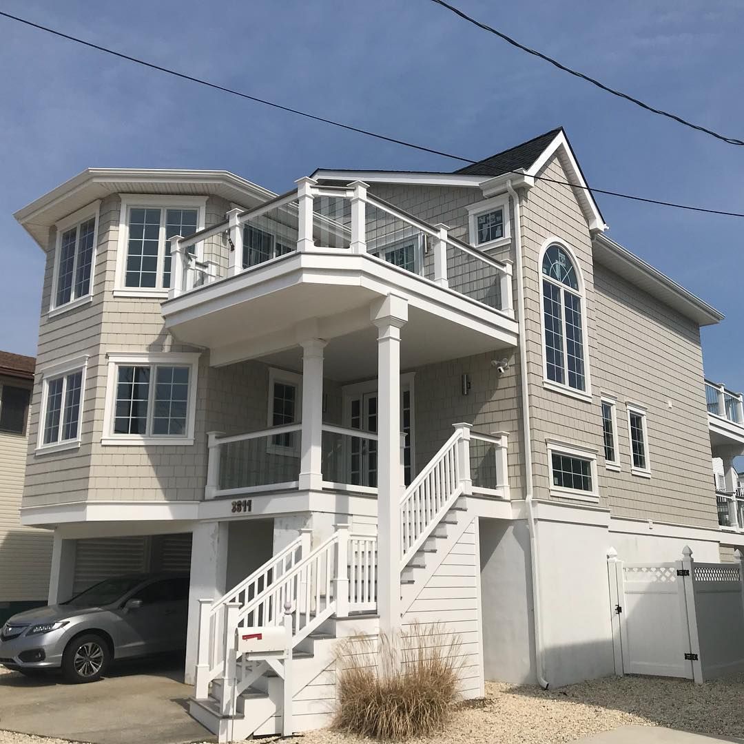 exterior renovation of a two-story beach house, gray siding, white trim and balcony in stone harbor, new jersey done by j.k. construction llc