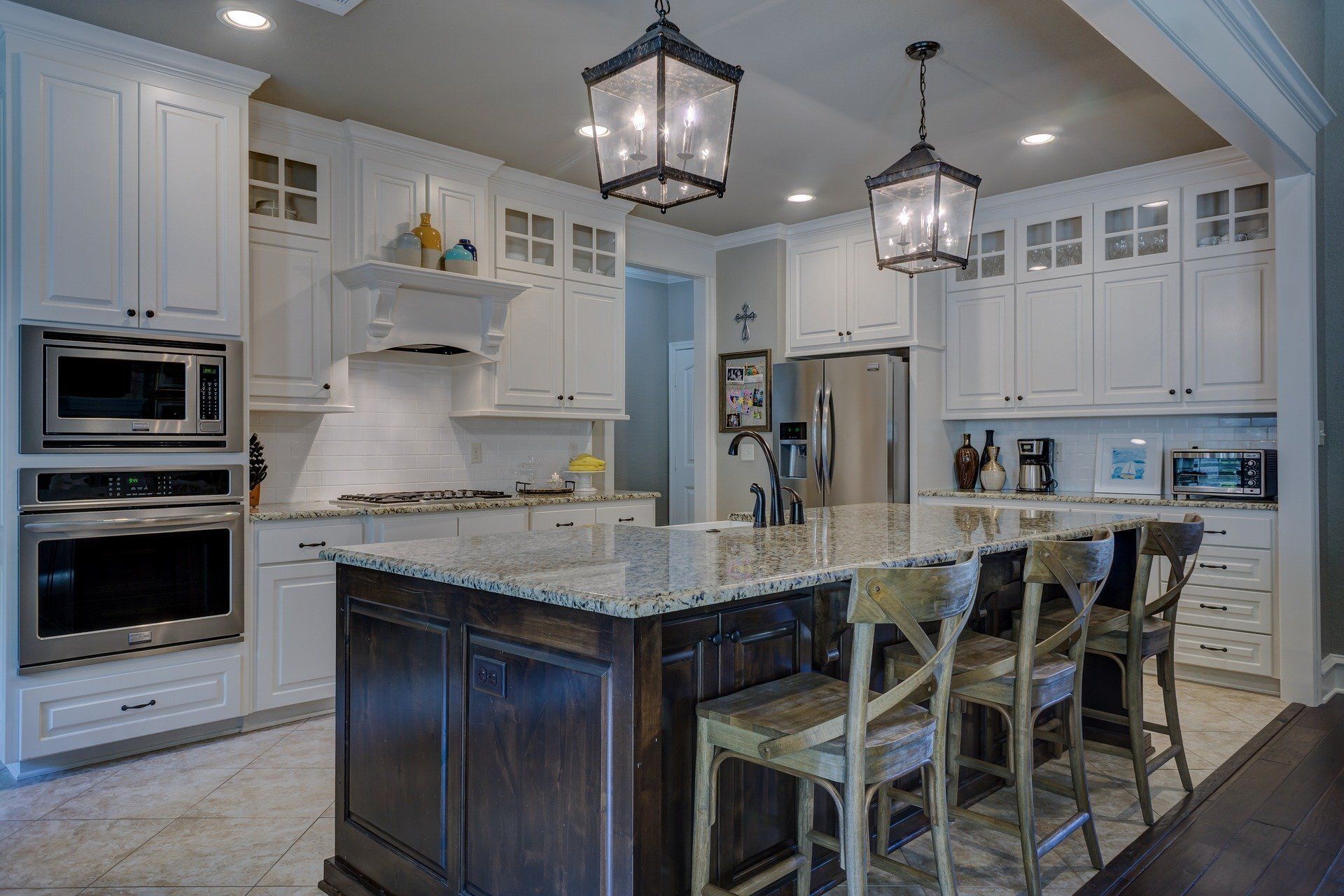 white kitchen with a granite island, black accents, and patterned backsplash remodeled by j.k. construction llc in strathmere, new jersey
