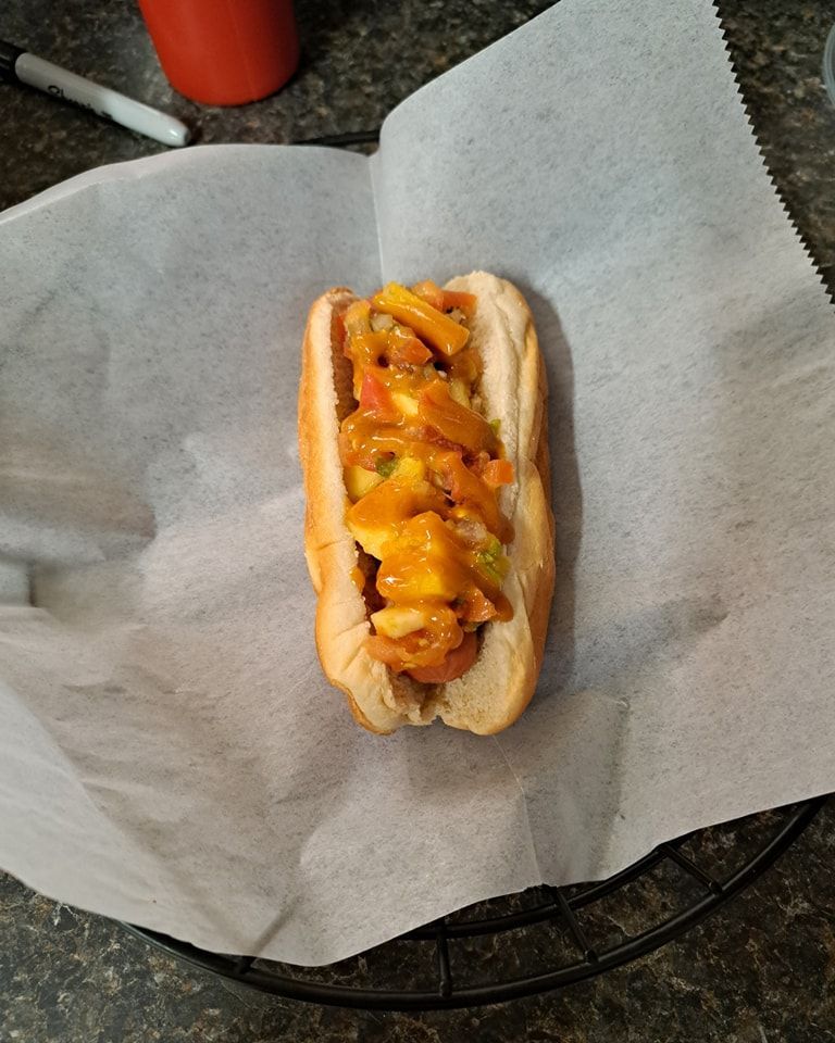 A hot dog is sitting on a piece of wax paper.