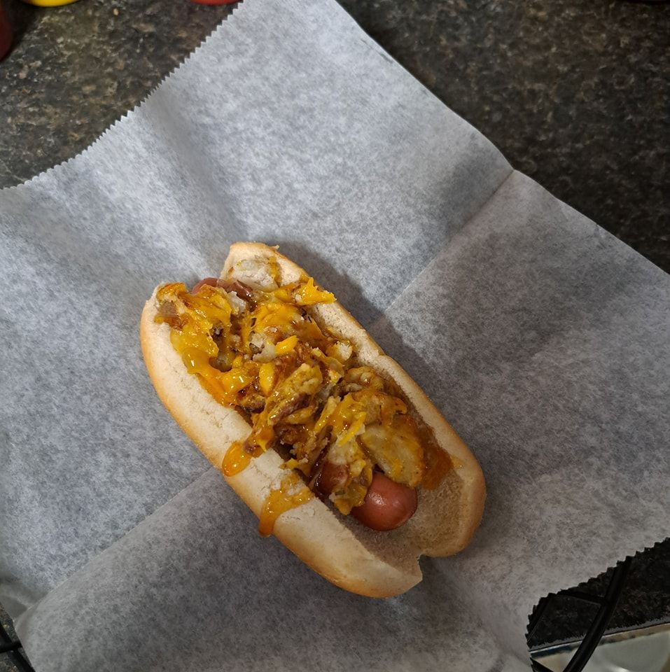 A hot dog with onions and mustard on a bun
