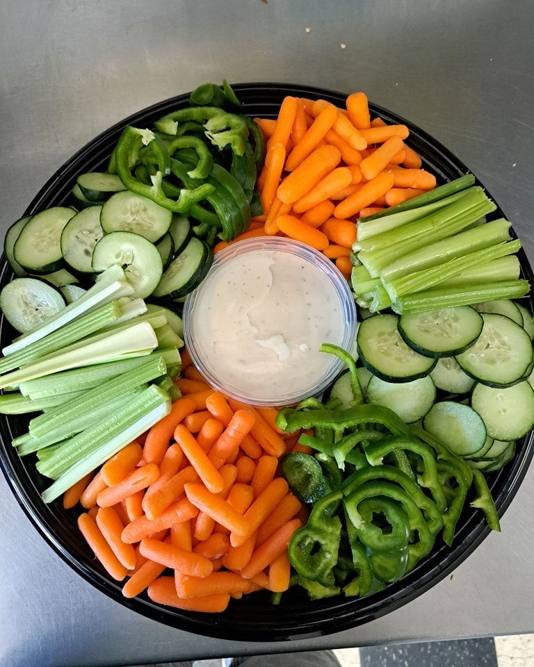 A tray of vegetables with a dipping sauce in the middle