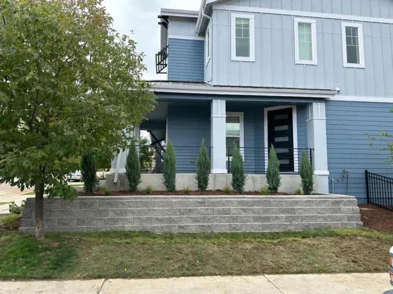A blue house with a porch and stairs in front of it.