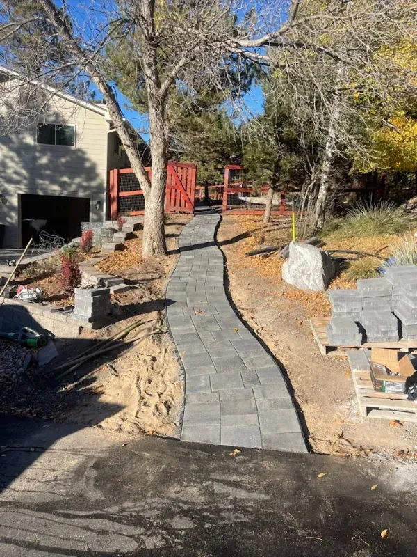 A walkway is being built in the backyard of a house.
