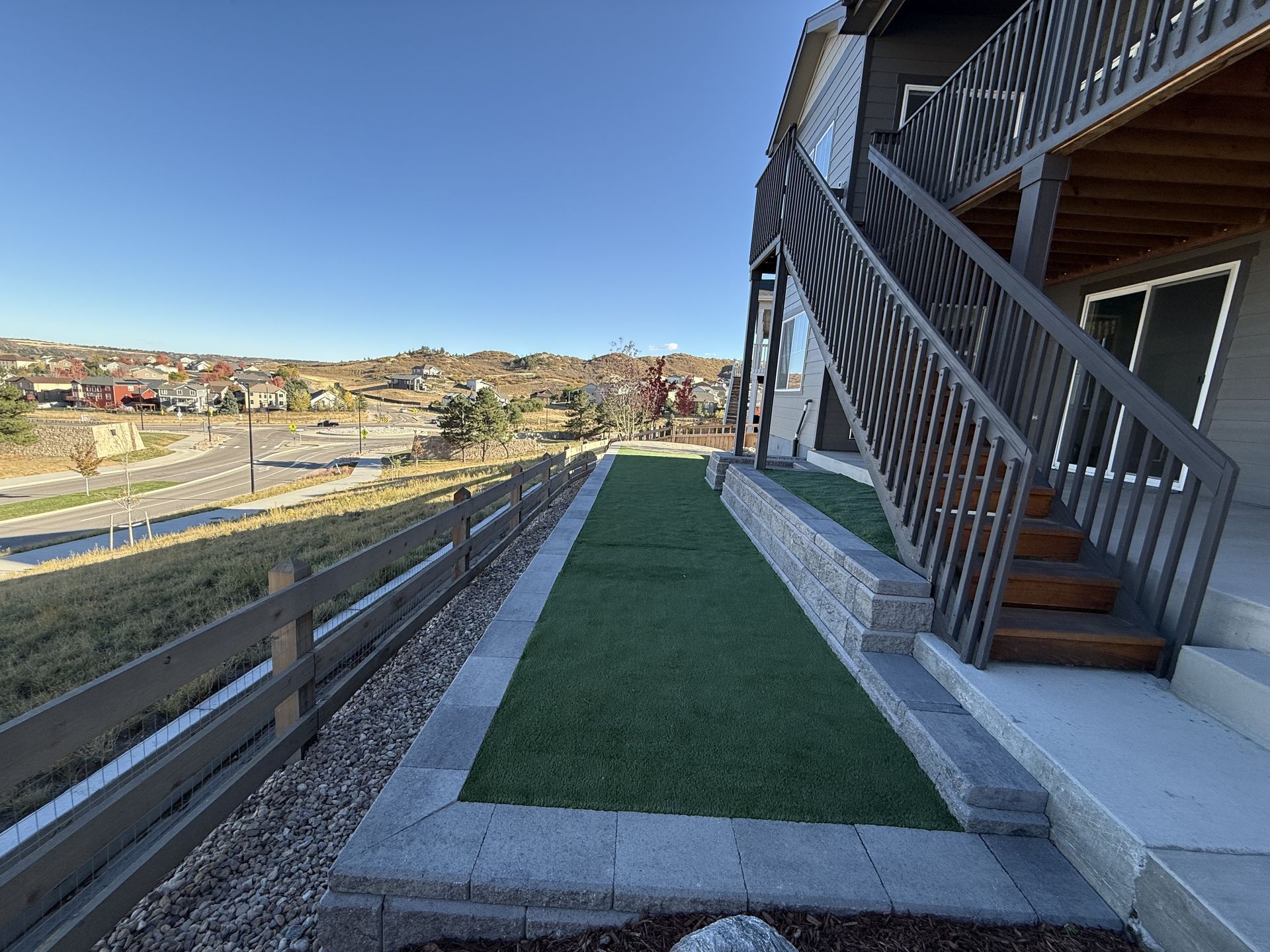 A house with stairs and a fence in front of it.