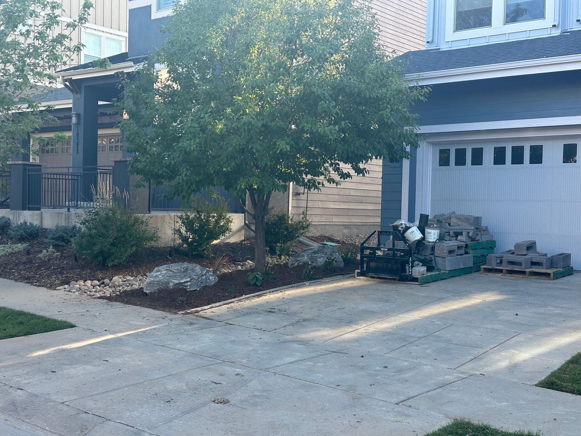 A house with a garage and a tree in front of it