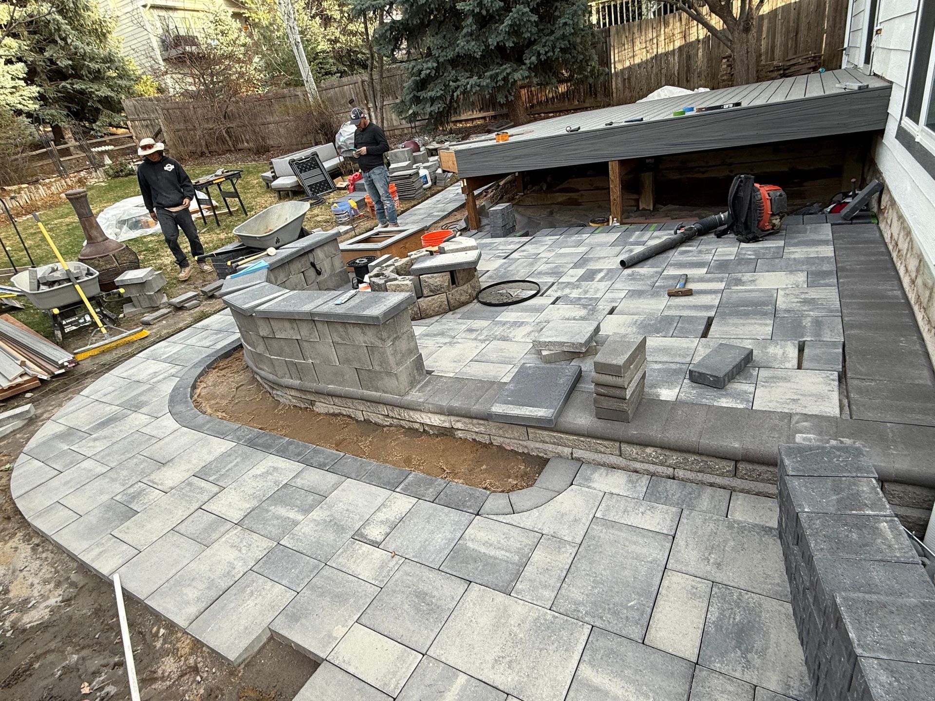 A patio is being built in the backyard of a house.