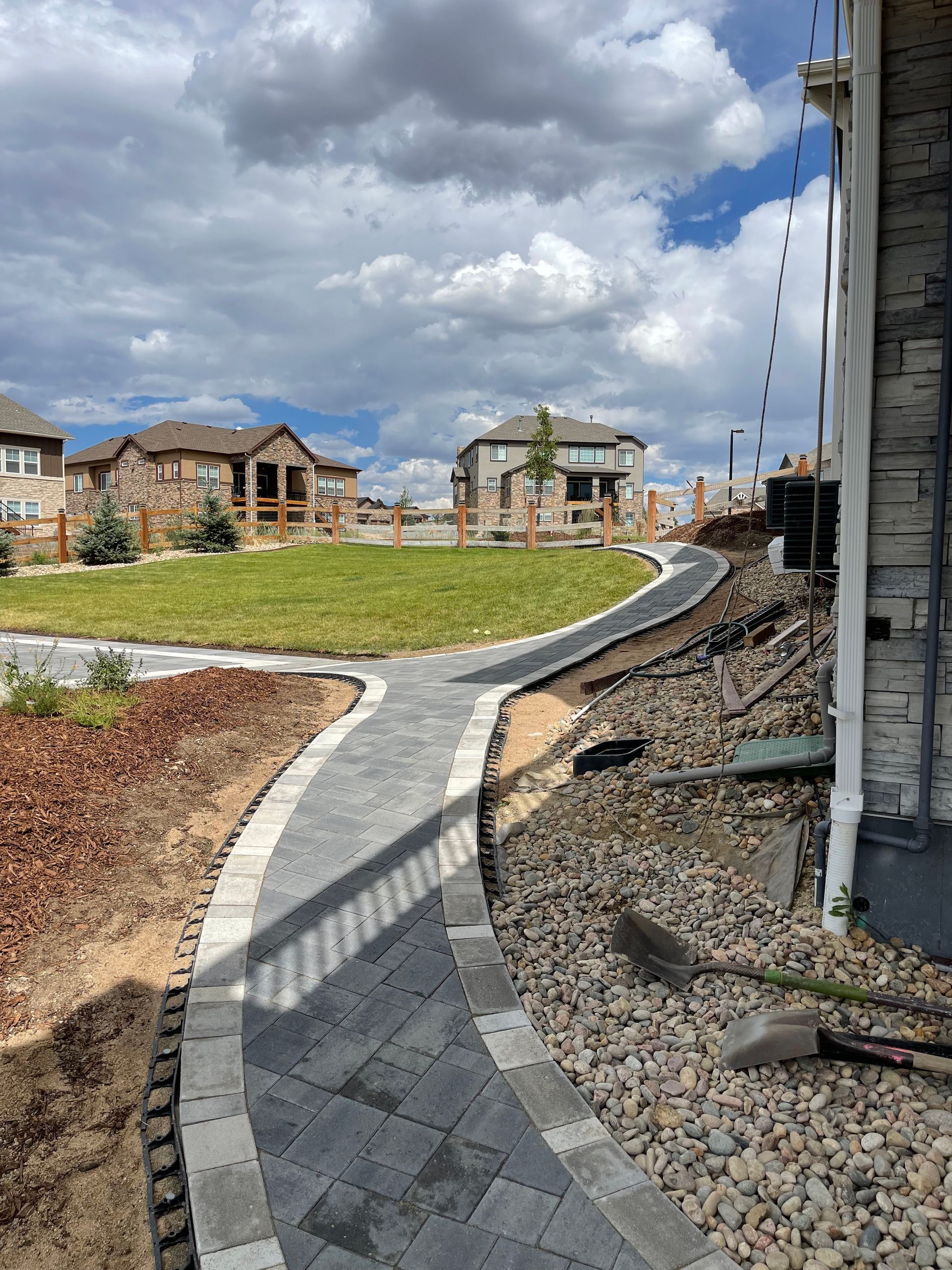 A walkway is being built in the backyard of a house.