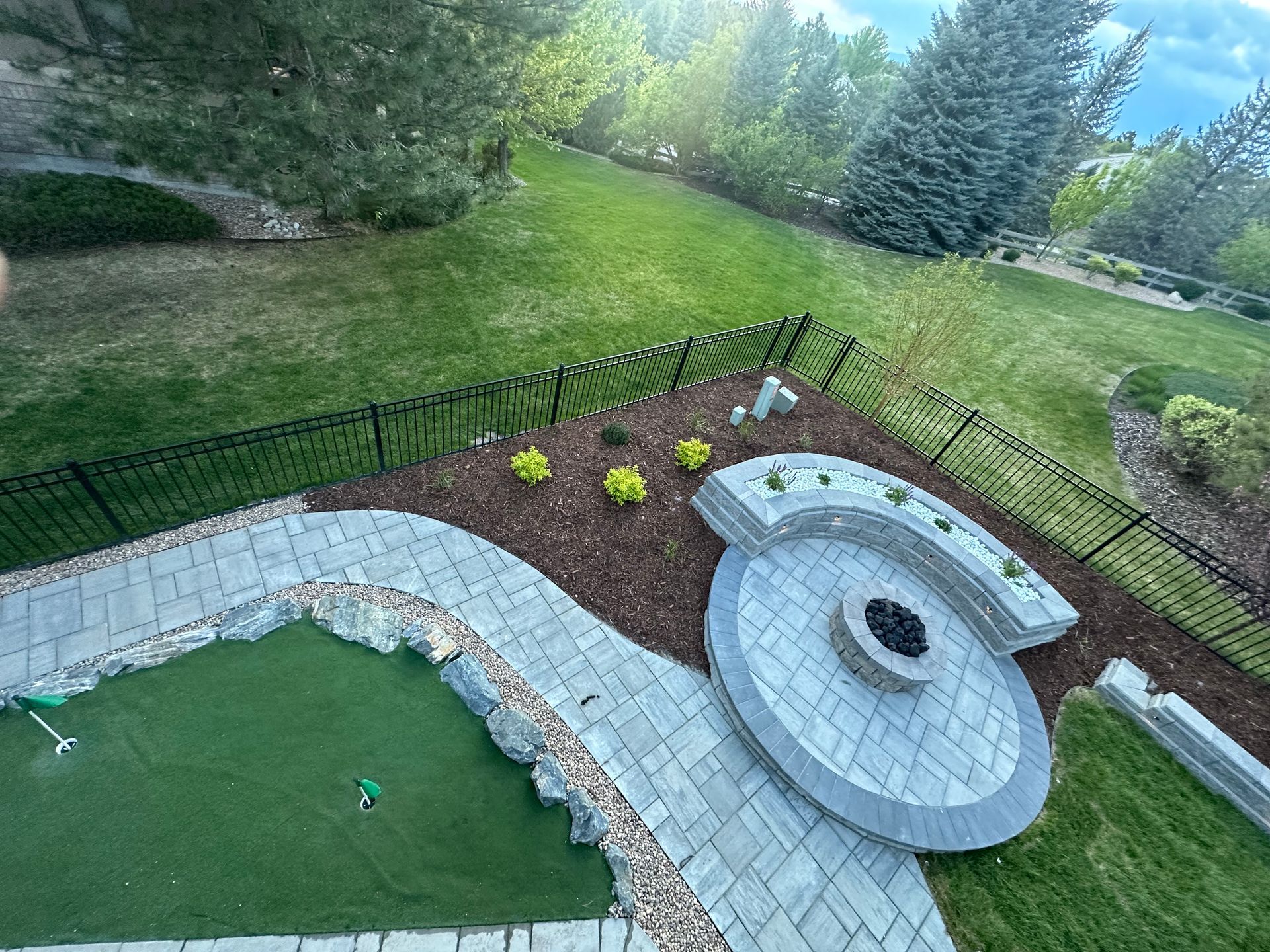 An aerial view of a backyard with a fire pit and a patio.