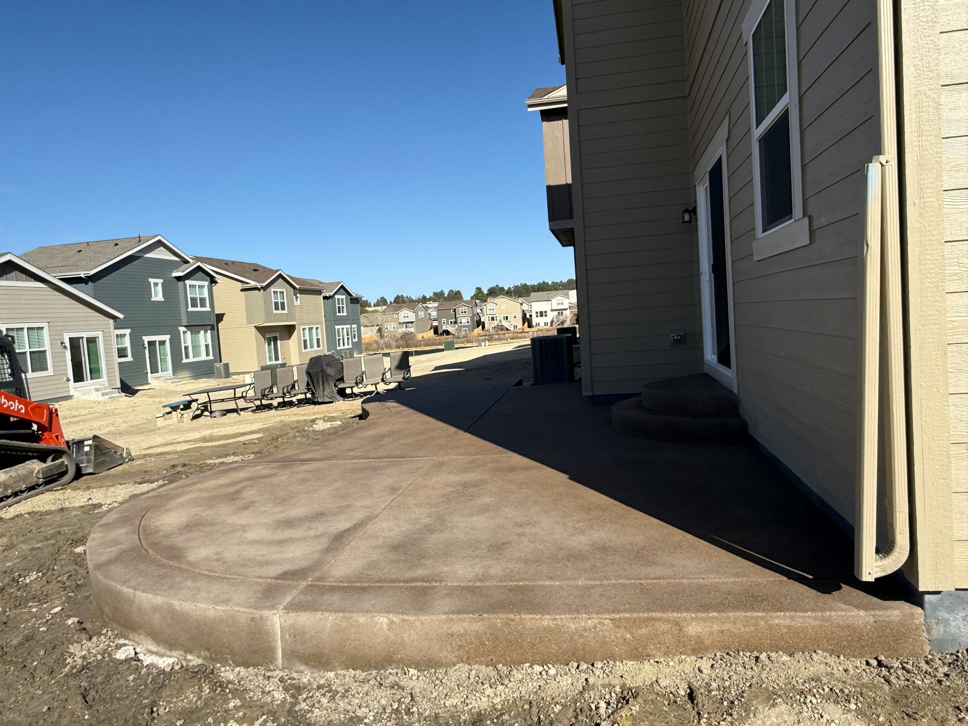 A concrete patio is being built in front of a house.