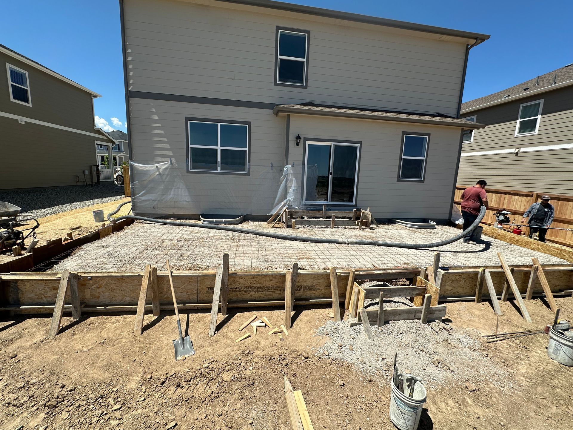 A house is being built with concrete being pumped into the ground.