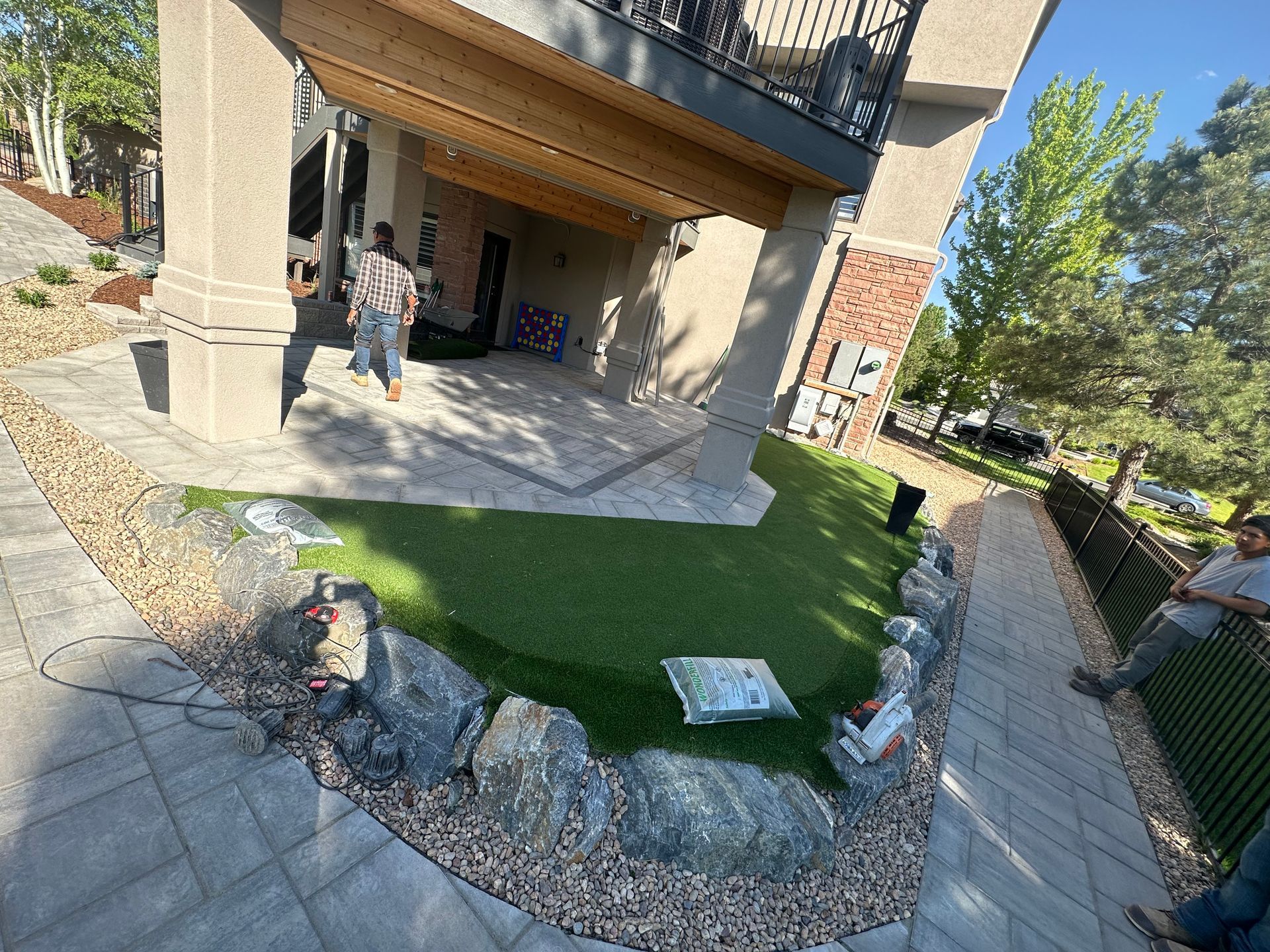 A man is standing in front of a house with a lawn in front of it.