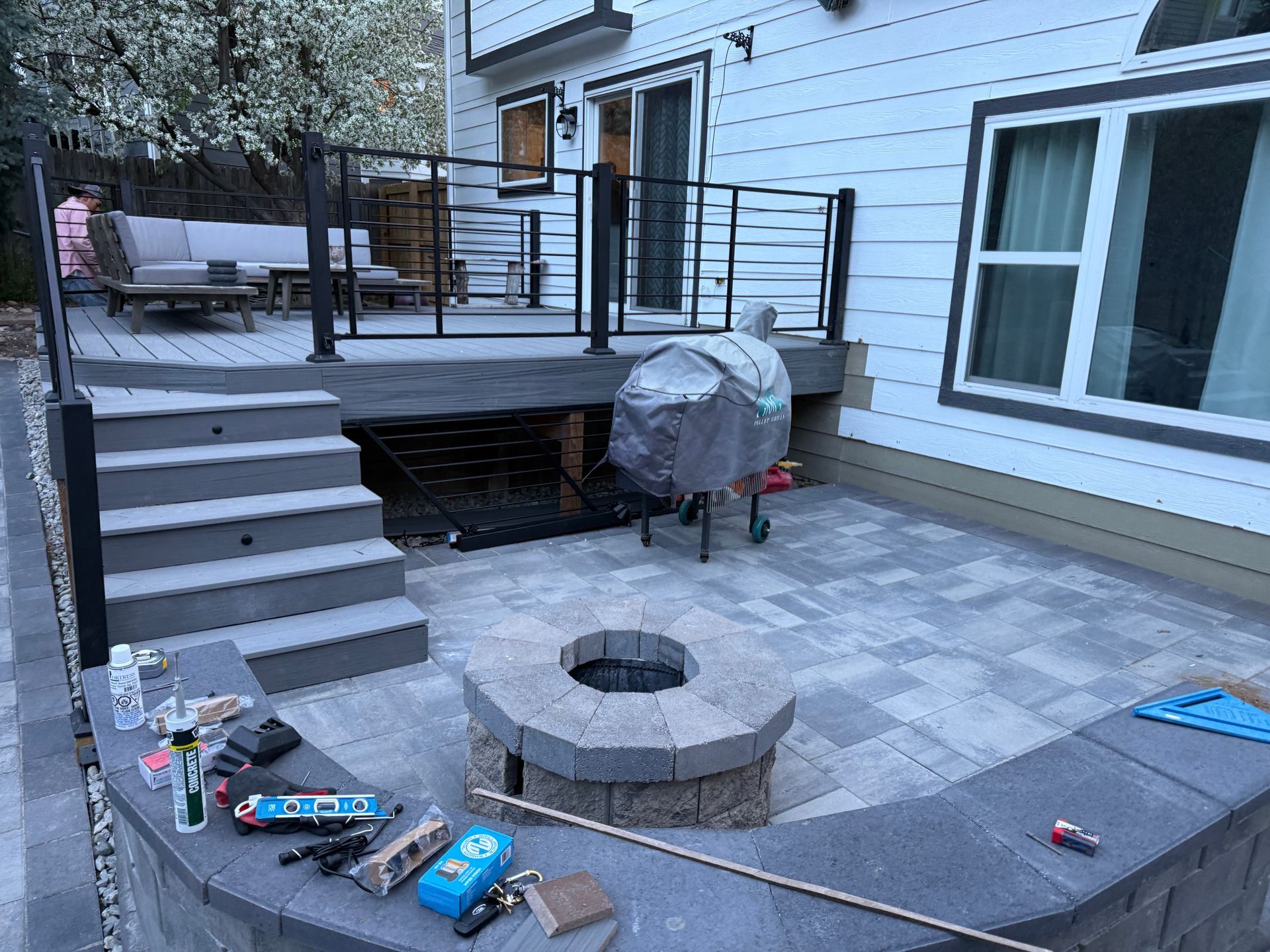 A fire pit is sitting on a patio next to a house.