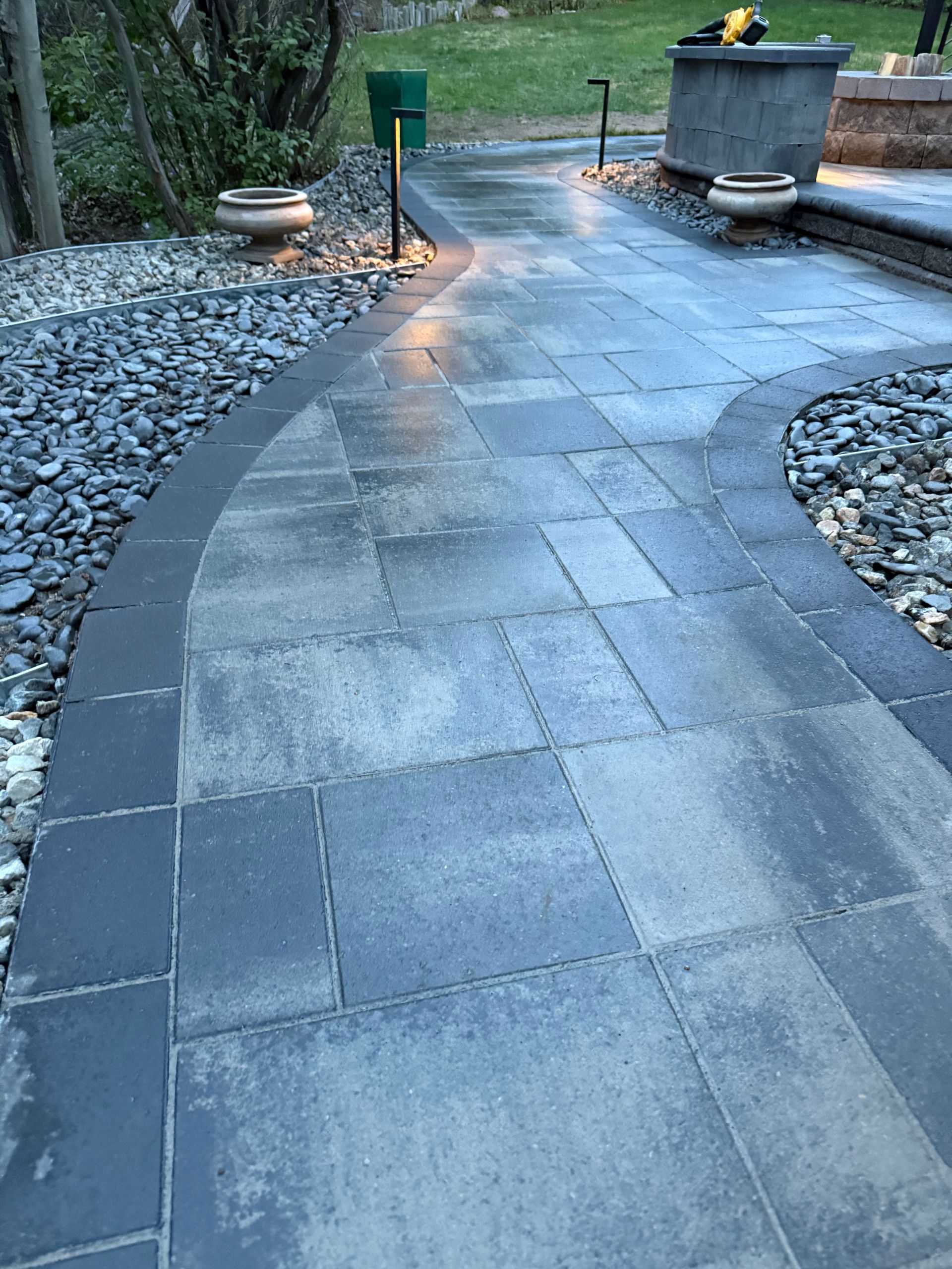 A patio with a circular walkway surrounded by rocks and trees.