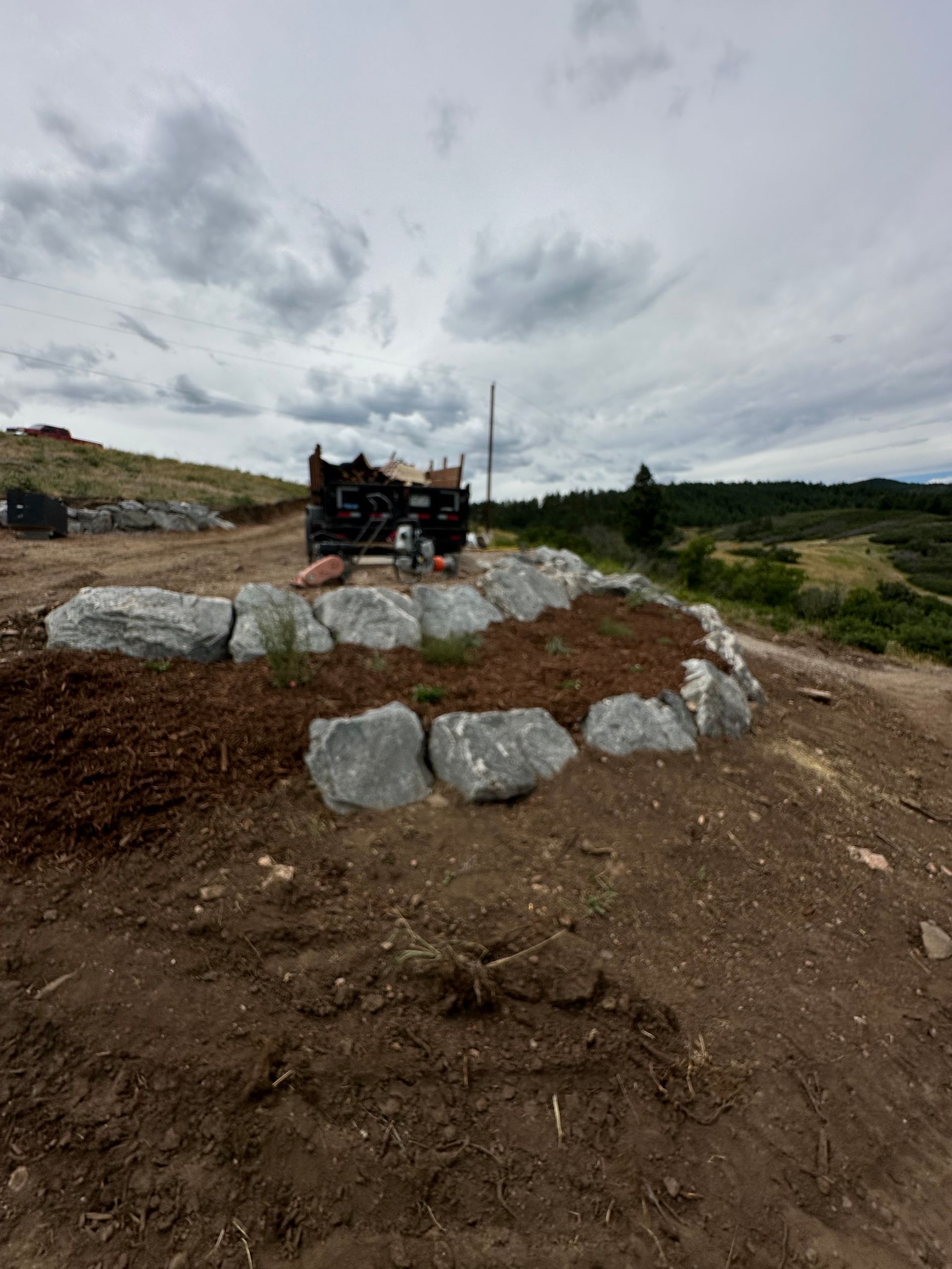 A large pile of rocks is sitting on top of a dirt hill.