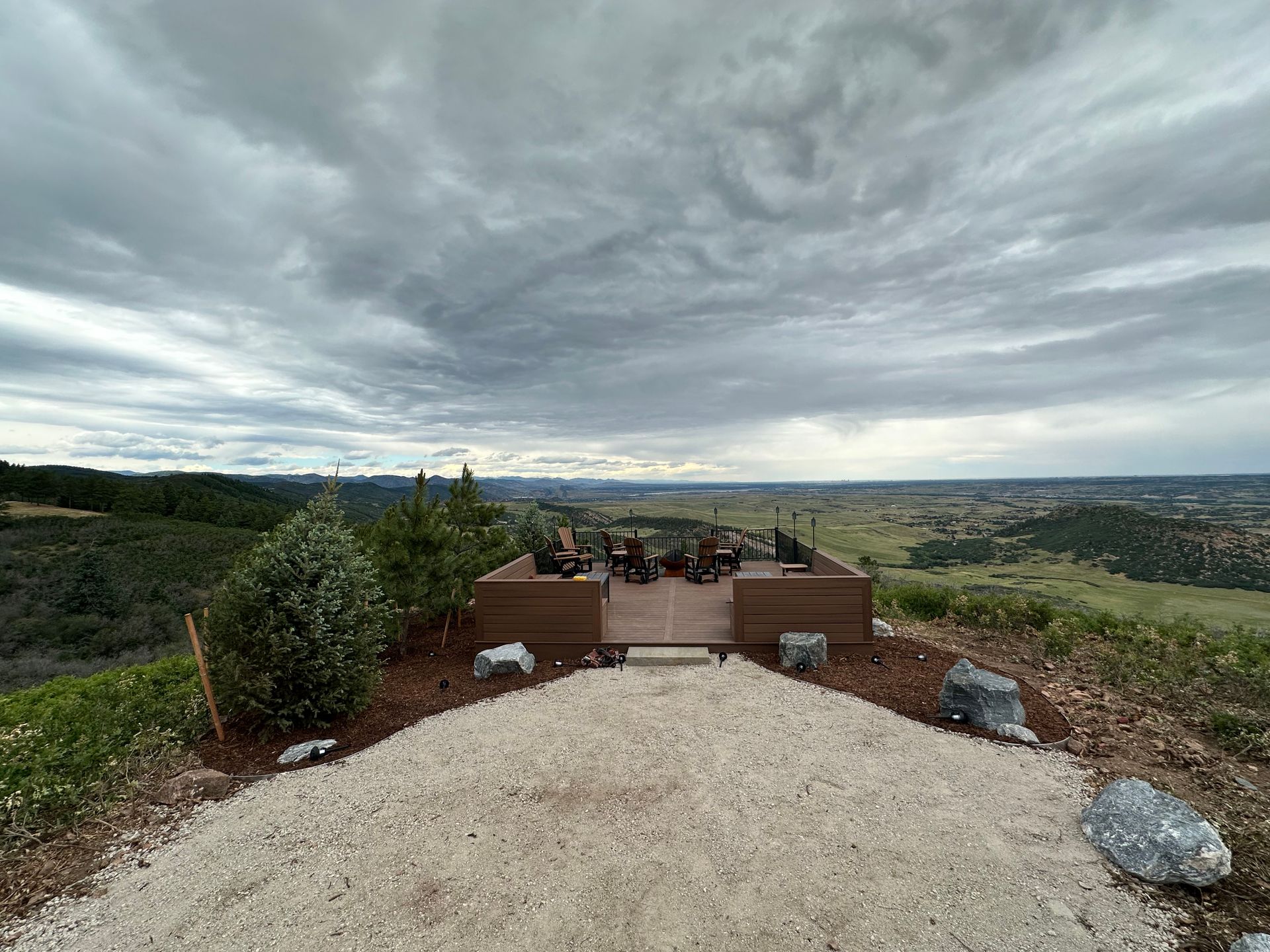 A large deck with a view of a valley on a cloudy day.