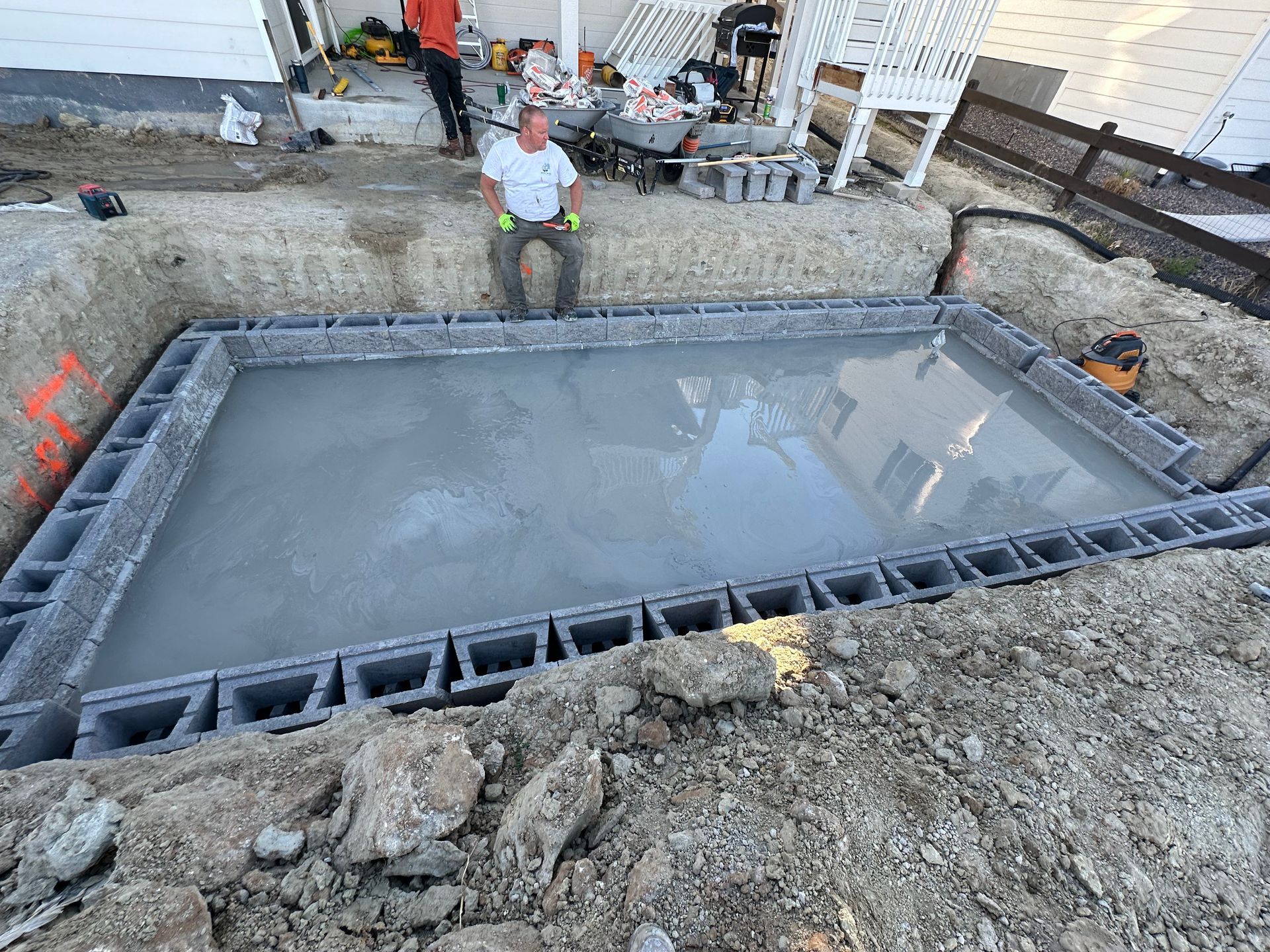 A man is sitting on top of a concrete slab.