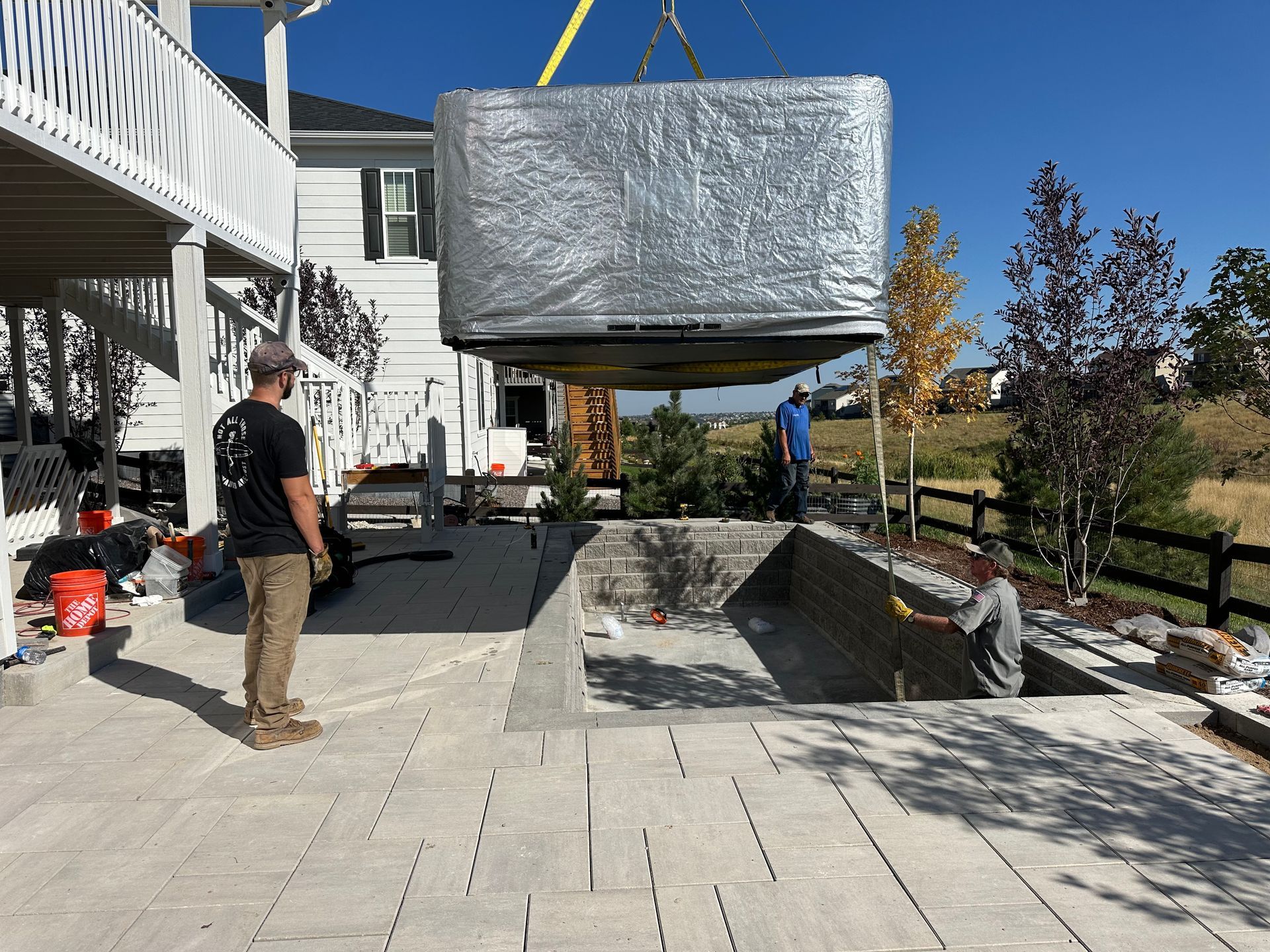 A hot tub is being lifted into a pool by a crane.