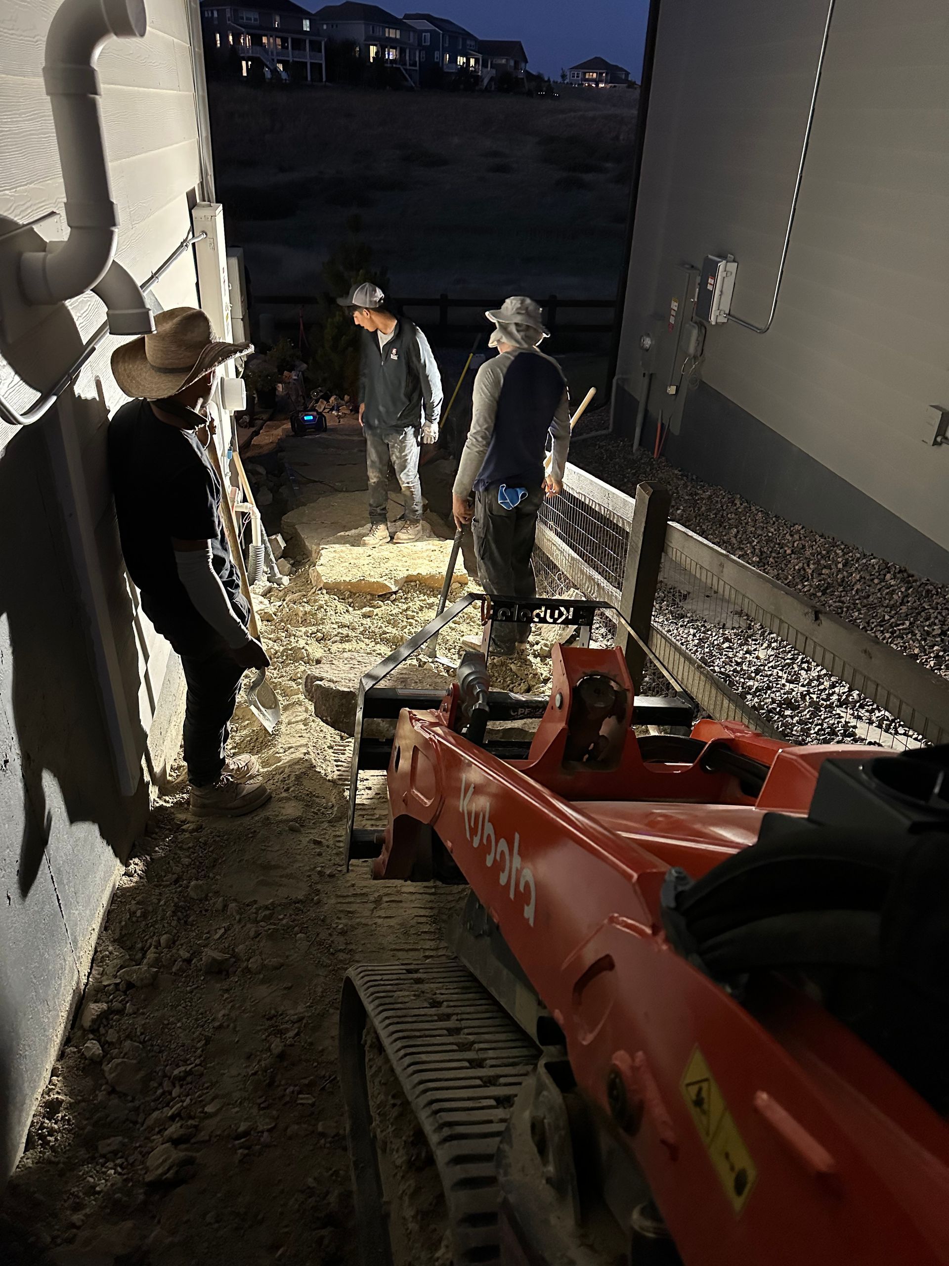 A group of men are working on a construction site at night.