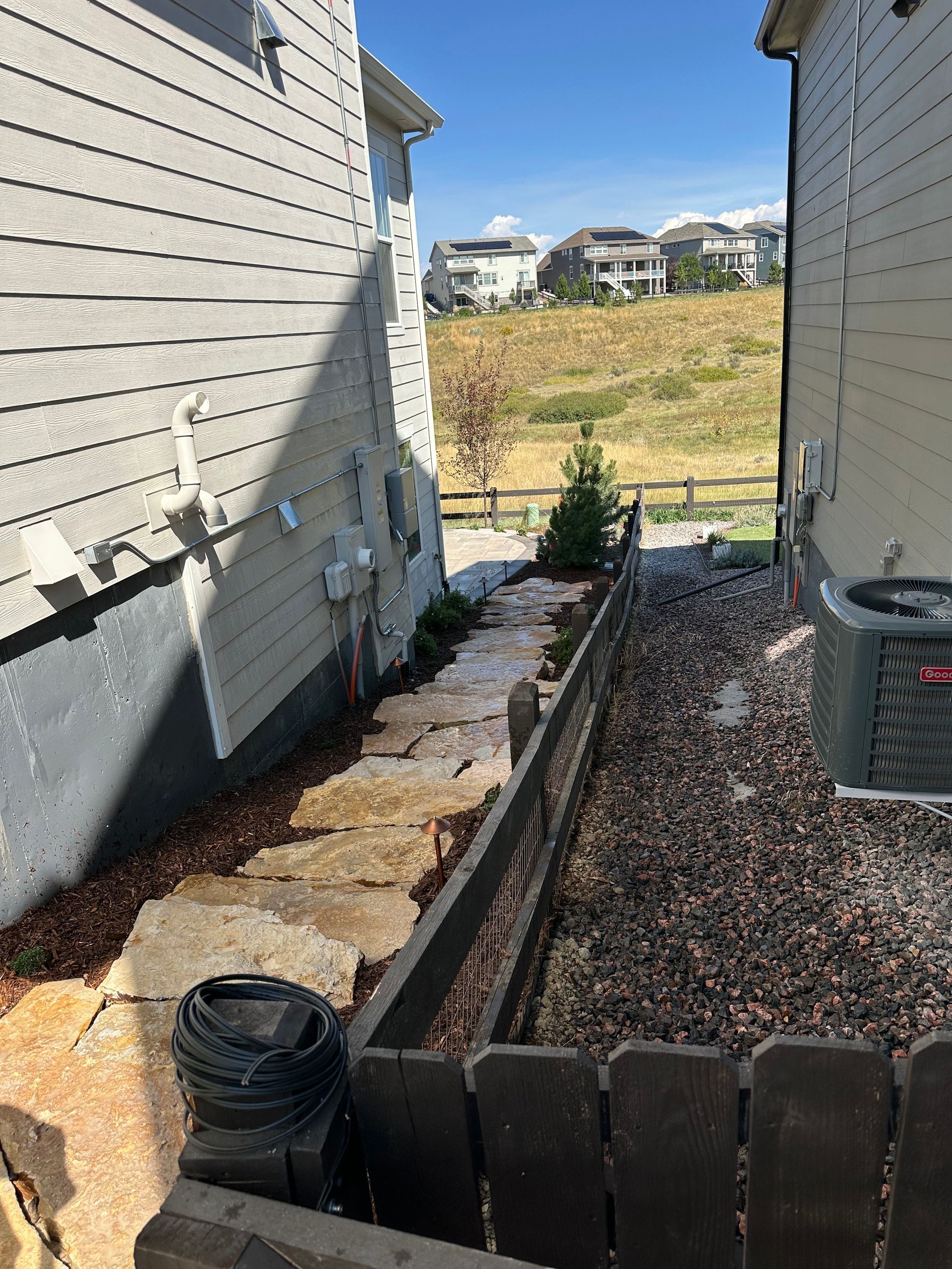 A house with a fence and a walkway between it and another house.