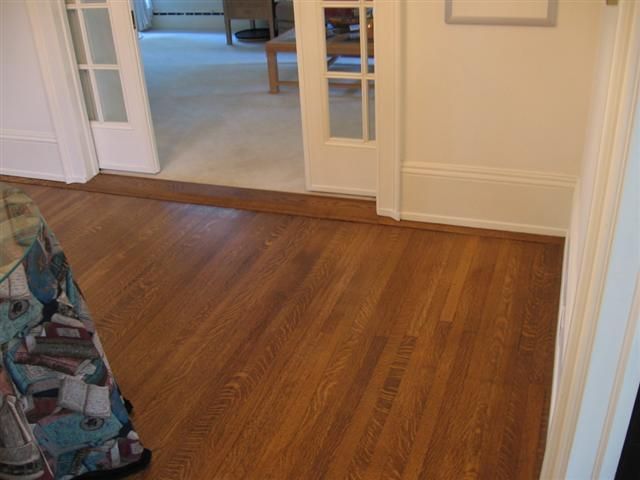 A wooden floor in a room with sliding glass doors.