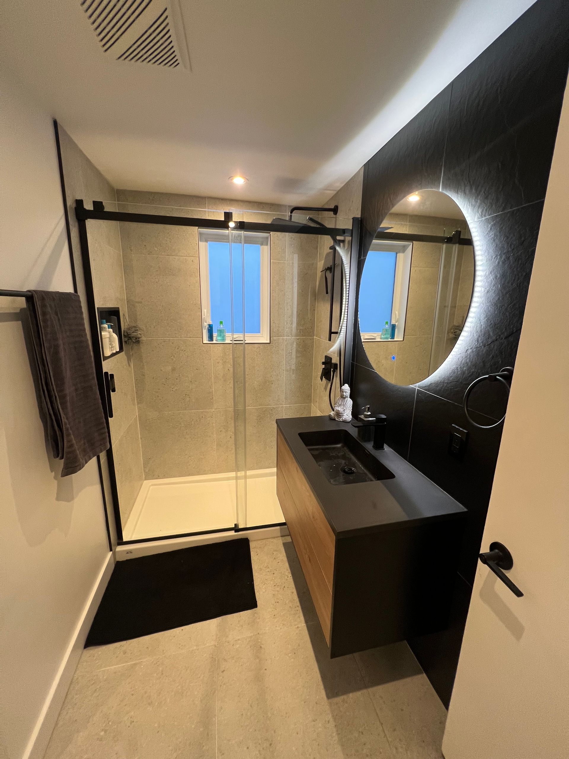 Une salle de bain avec un lavabo, un miroir et une douche