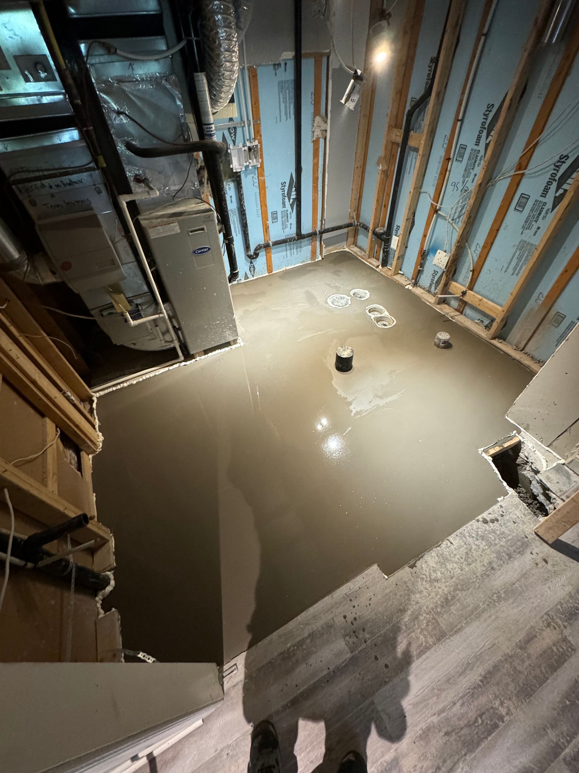 Une personne se tient dans une pièce avec beaucoup de béton sur le sol.