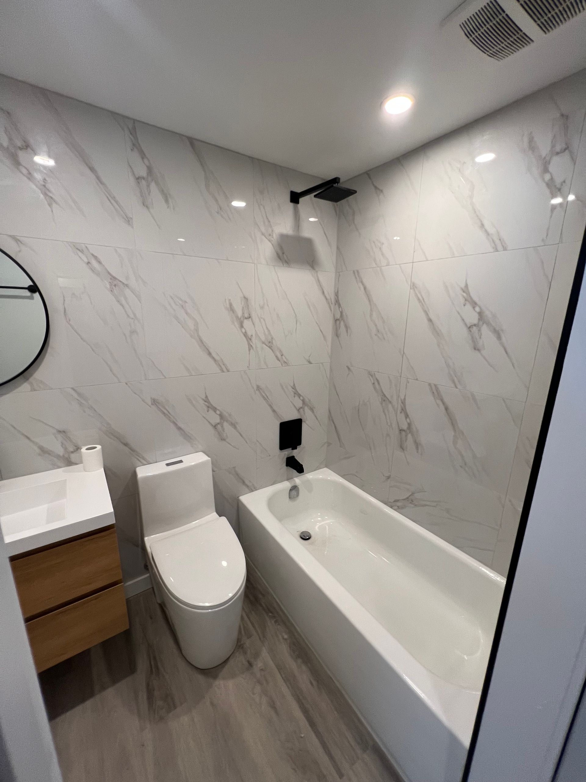 Une salle de bain avec WC, lavabo et baignoire.