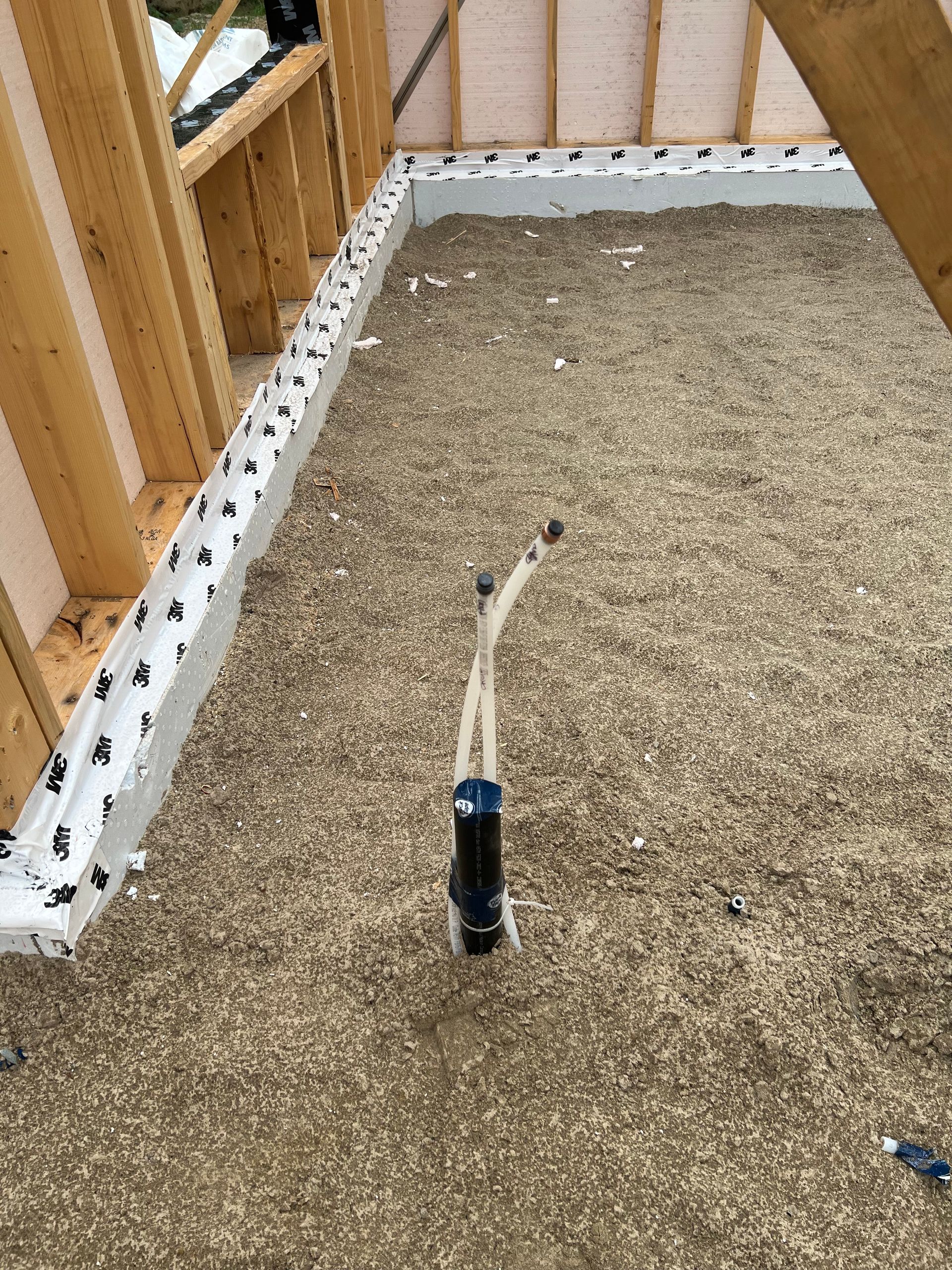 Un tuyau est posé sur le sol dans un bâtiment en construction.