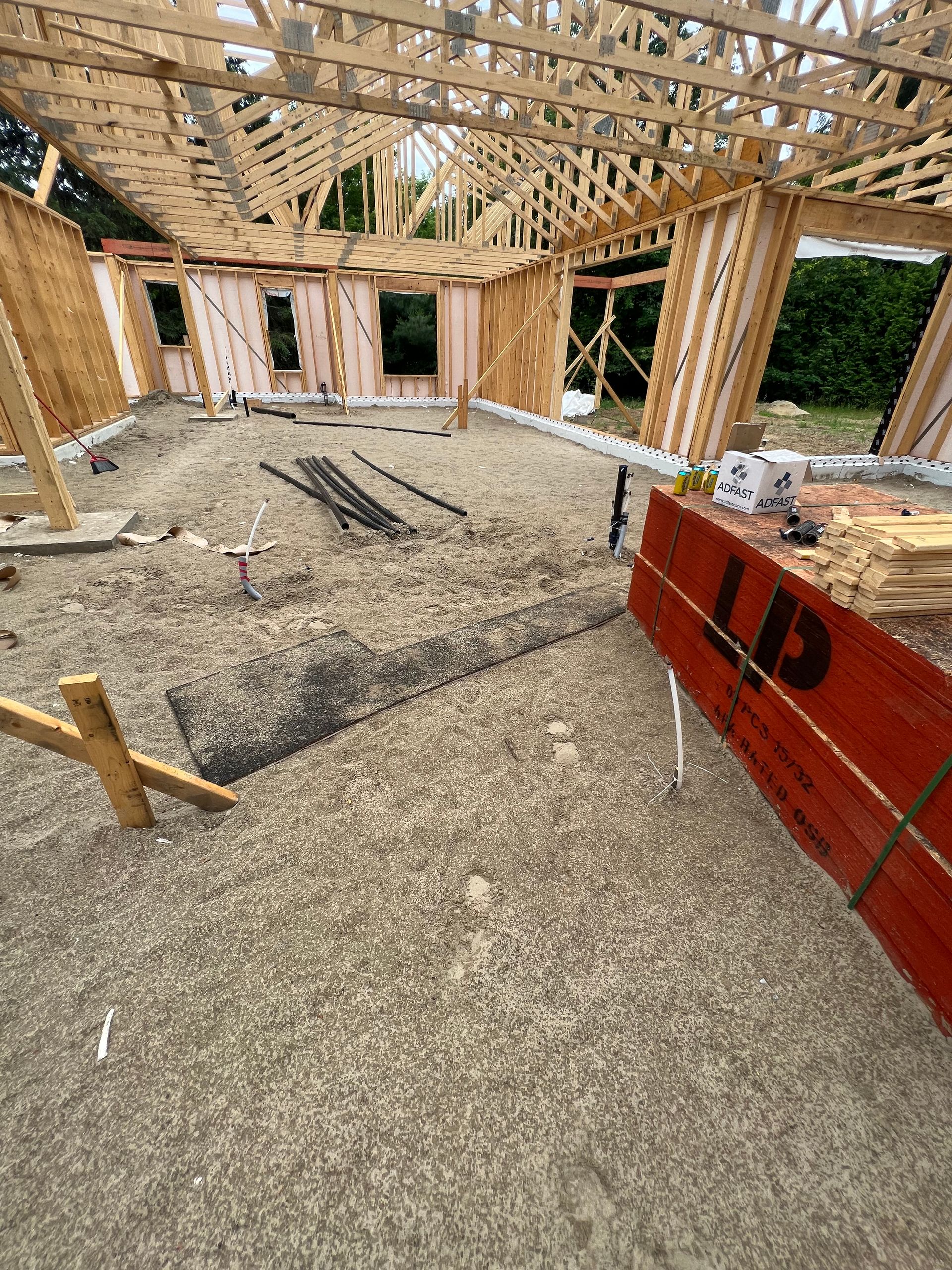 Une maison est en train d'être construite avec beaucoup de bois.