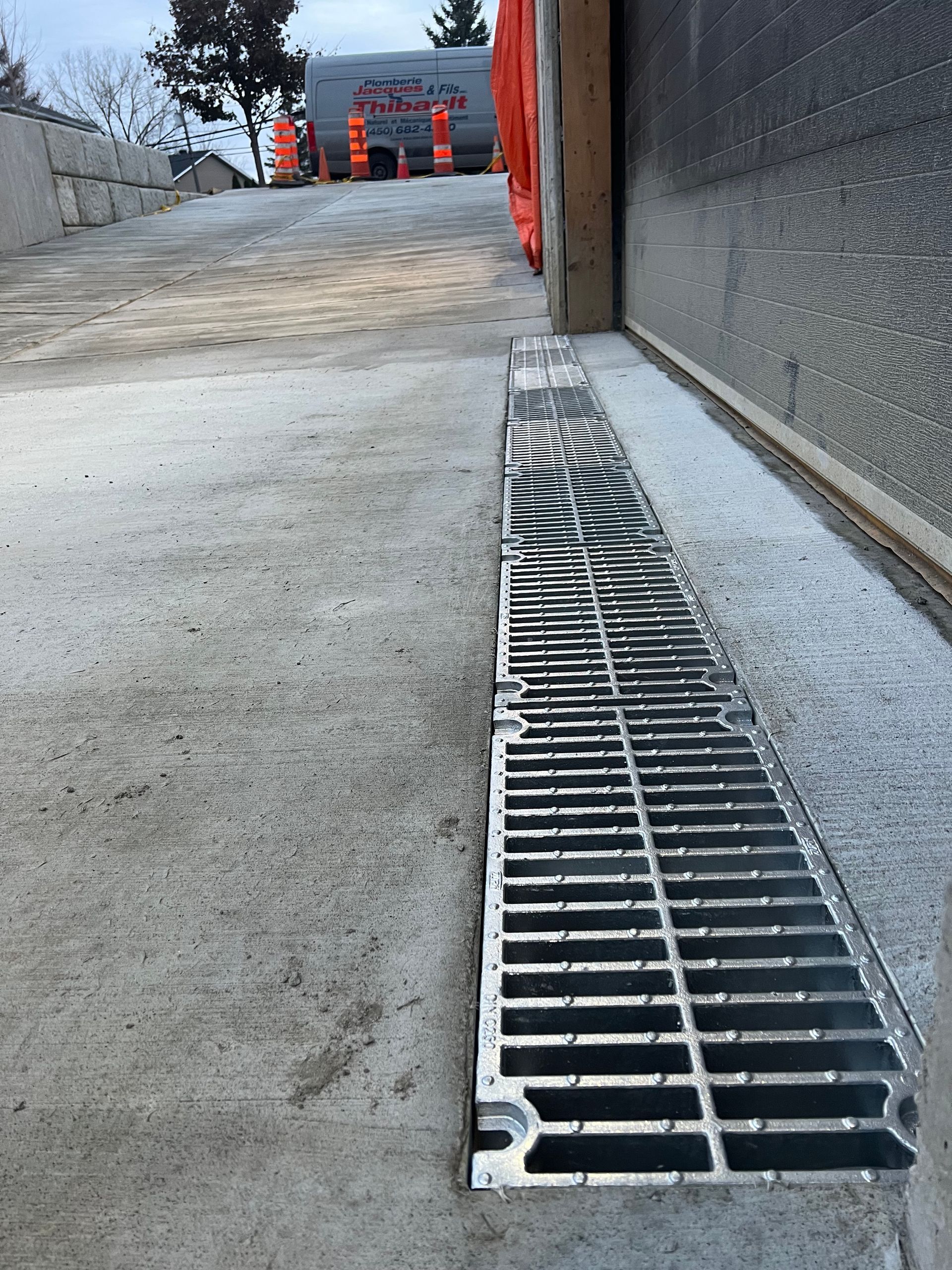 Un drain sur un trottoir à côté d'un bâtiment