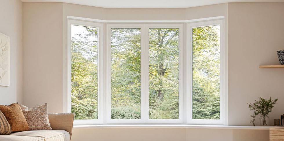 A living room with a large bay window and a couch.