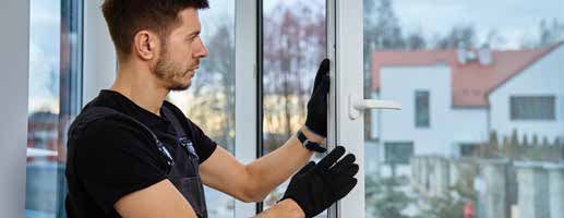 A man is installing a window in a house.