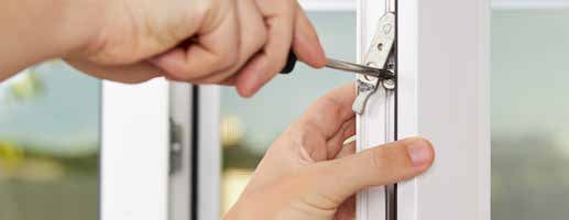 A person is fixing a window with a screwdriver.