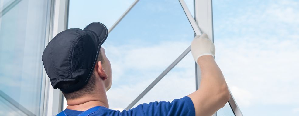 A man is installing a window in a building.