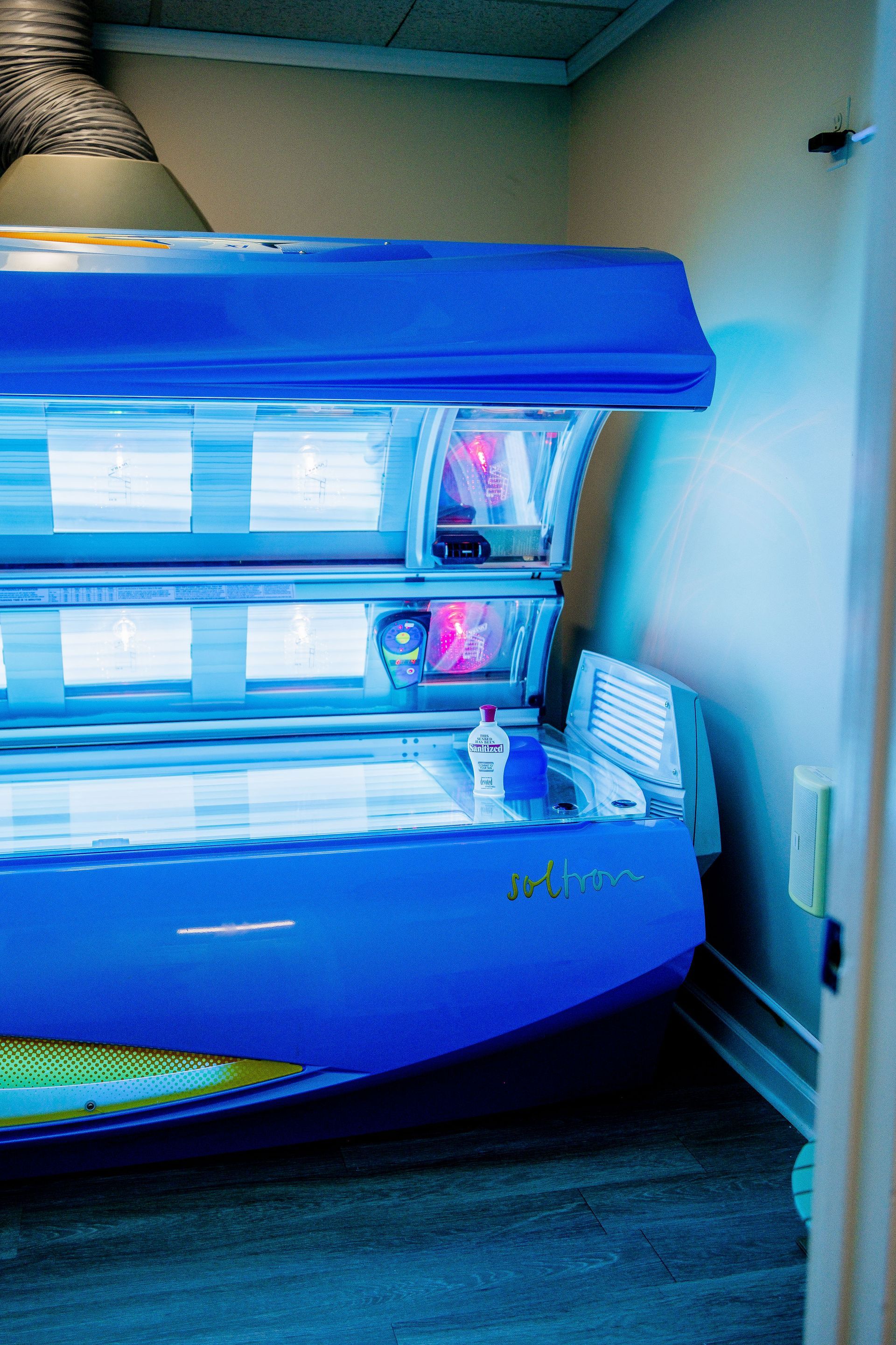 Blue tanning bed in a room with a closed door.