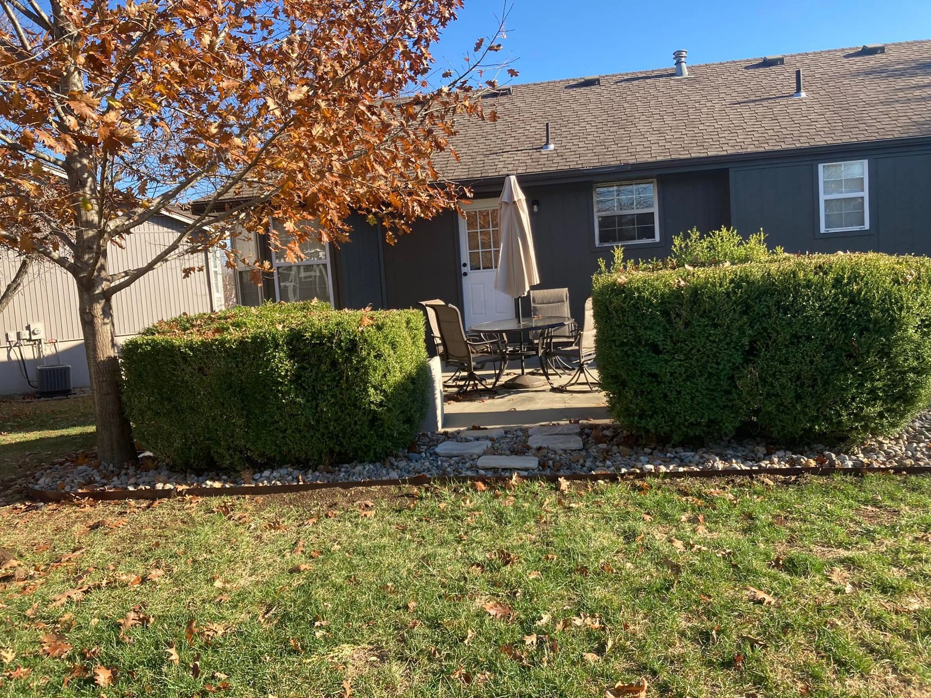 A house with a patio and a tree in front of it