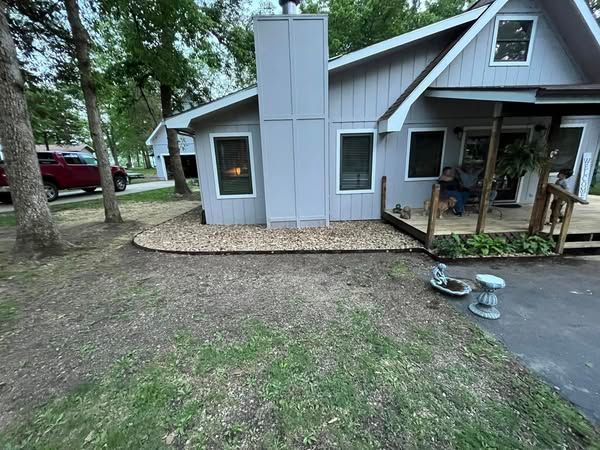 A man is sitting on a porch in front of a house.