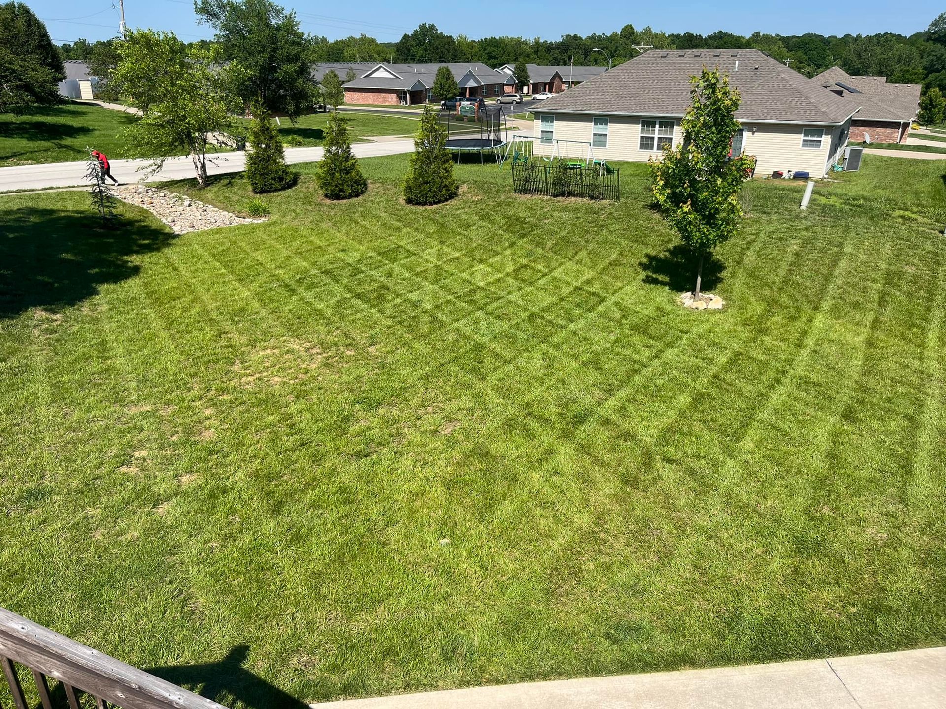 An aerial view of a lush green lawn in front of a house.