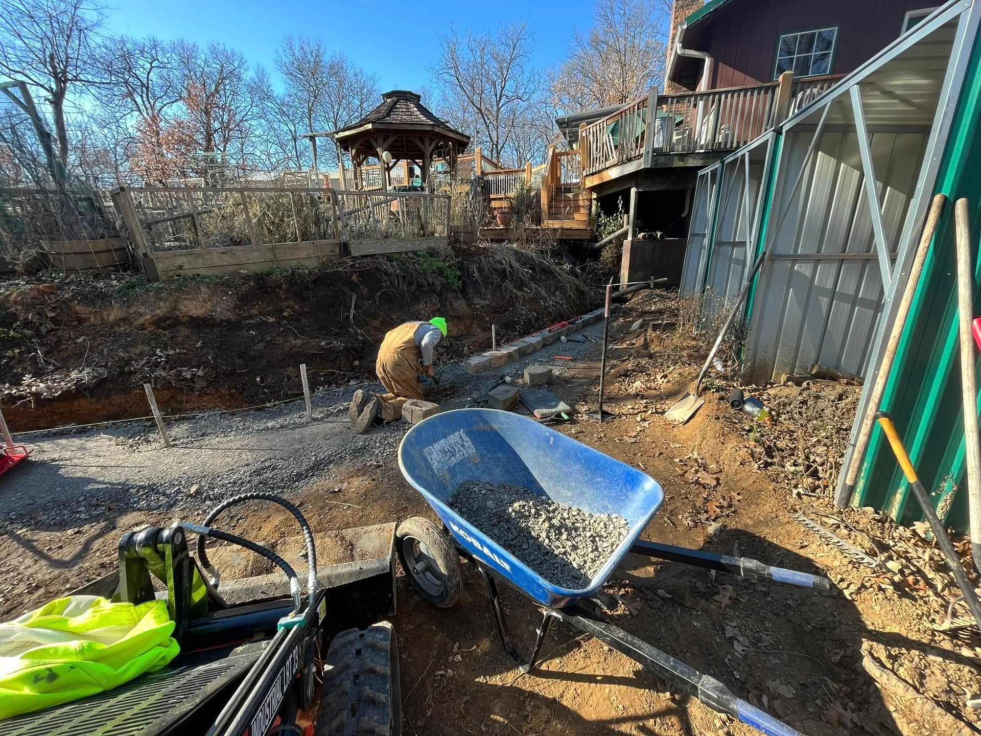 A wheelbarrow filled with dirt is sitting in front of a construction site.