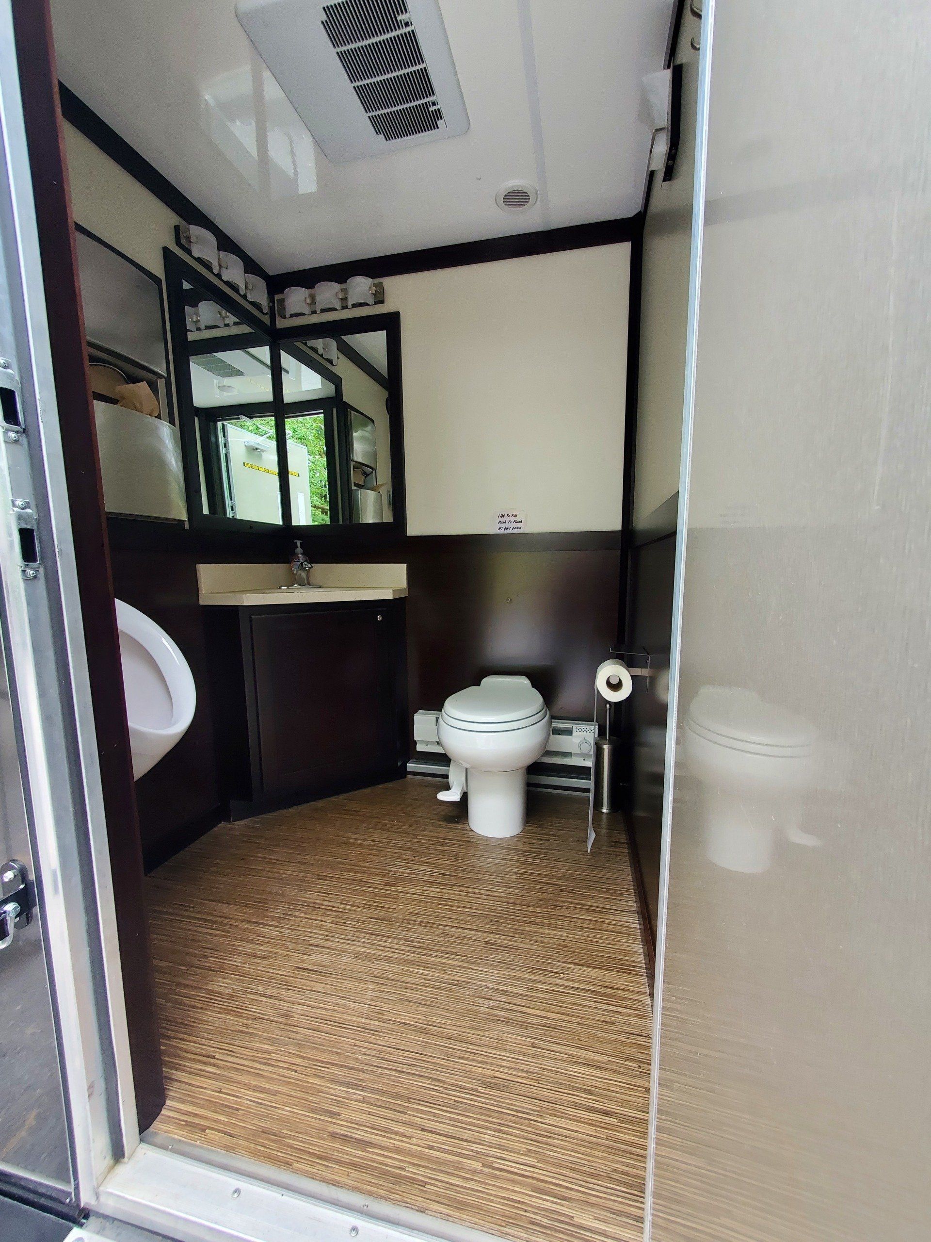A bathroom with a toilet , urinal , sink and mirror.