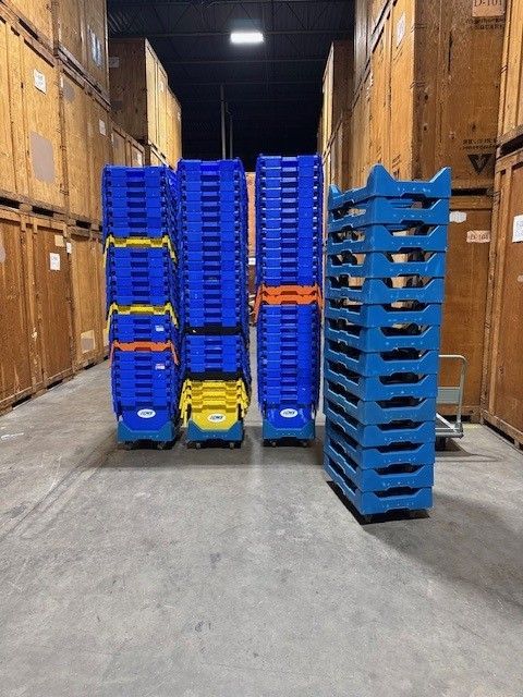 Blue plastic moving bins stacked high in a storage facility.