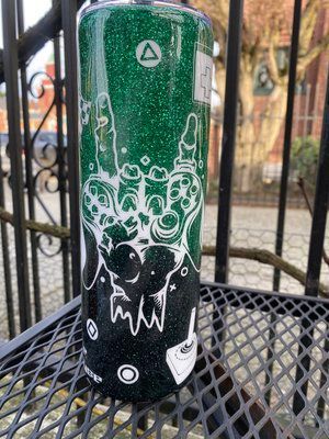 Green and black glitter tumbler with white video game controller design.