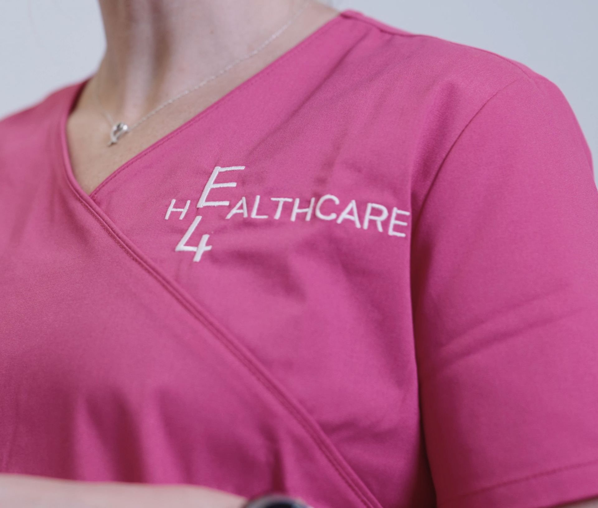 E4 healthcare logo on pink scrubs 