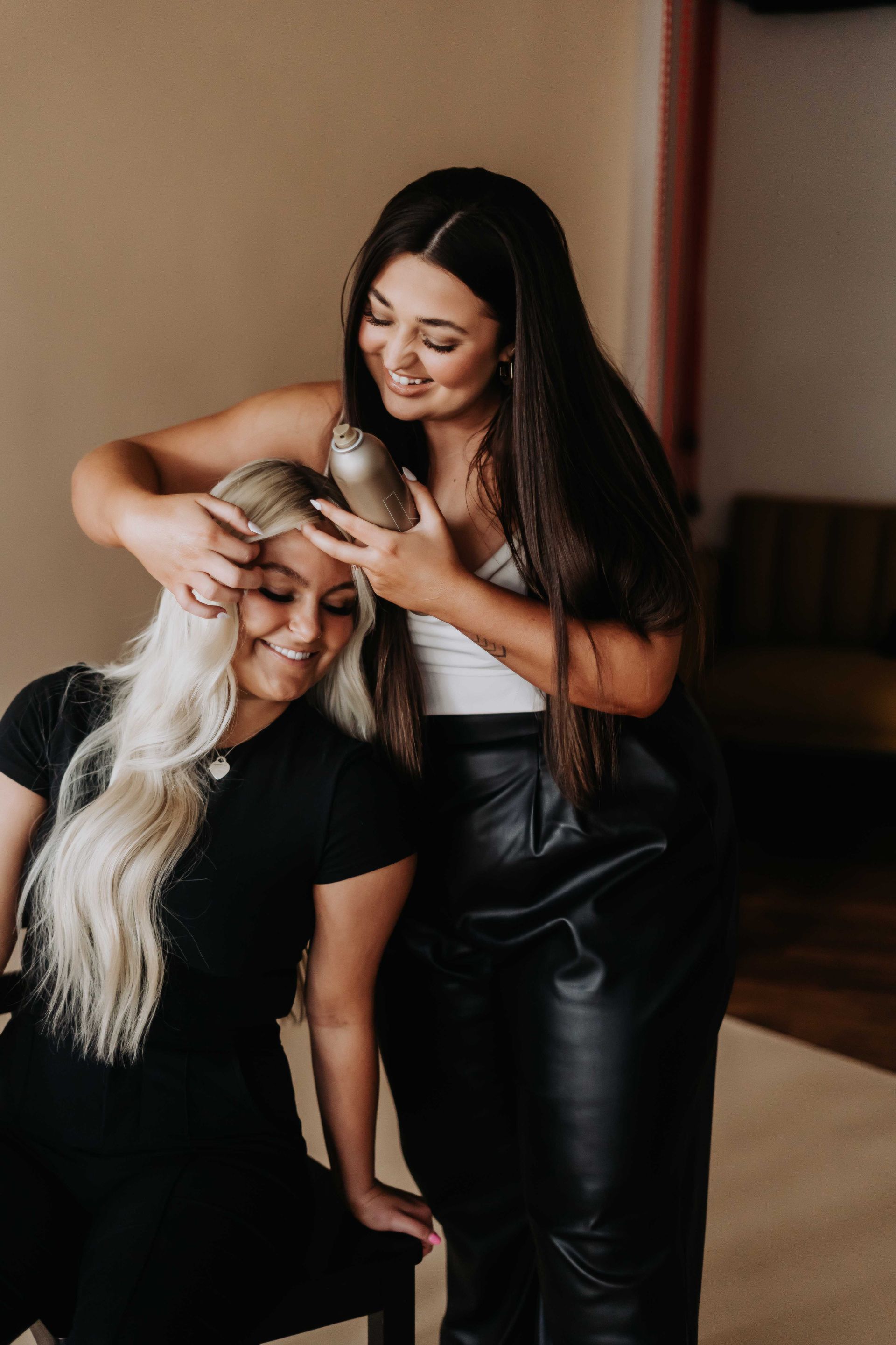 Two women are brushing each other 's hair in a room.
