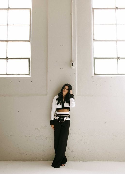 A woman wearing a white shirt is smiling for the camera