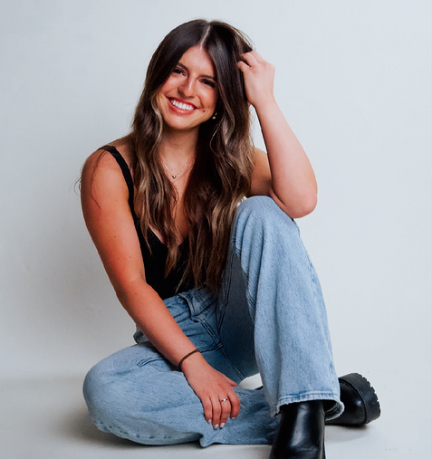 A woman wearing a white shirt is smiling for the camera