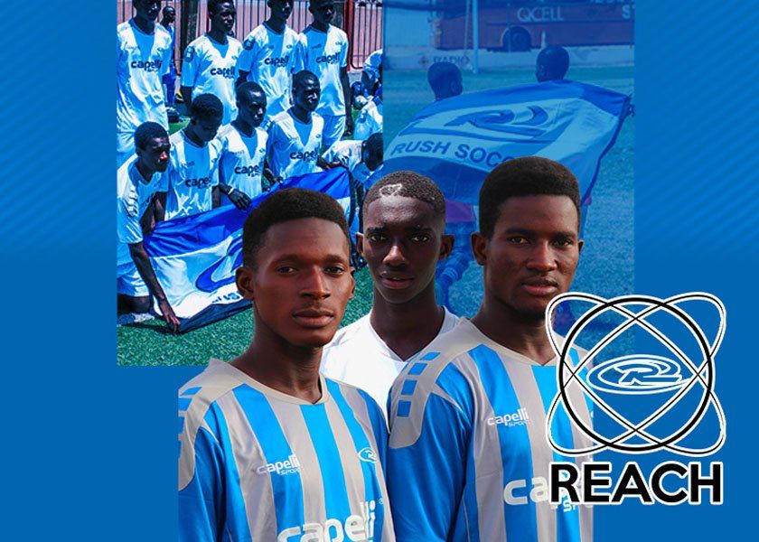 Soccer team in blue and white jerseys with Rush Soccer logo, posing outdoors.