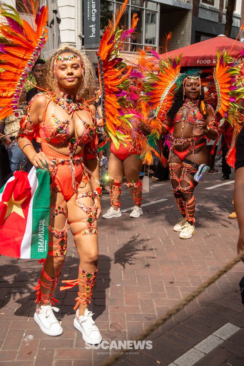 A woman in a colorful costume is walking down the street.